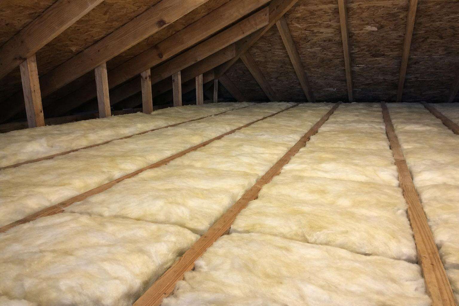 Fresh insulation batts laid between attic joists