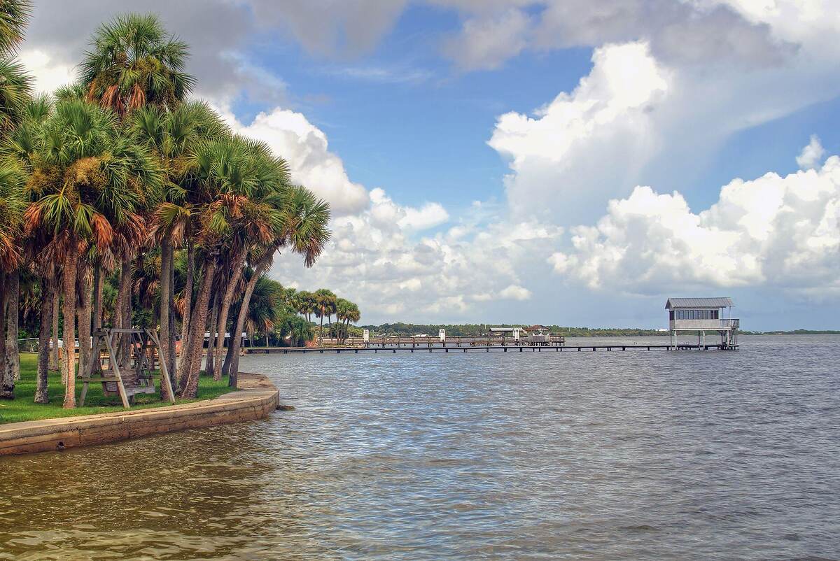 A wooden dock reaching into a broad lake