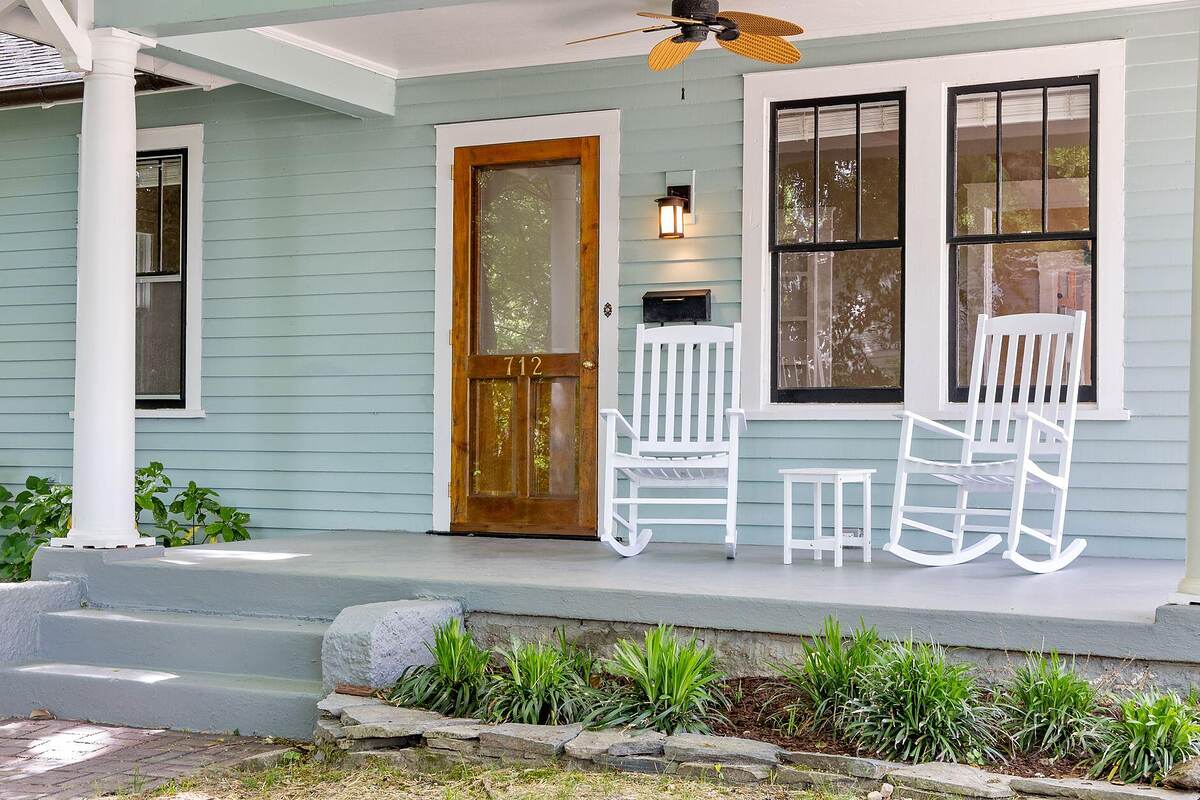 A wood-frame Craftsman bungalow with a deep front porch on a shaded lot