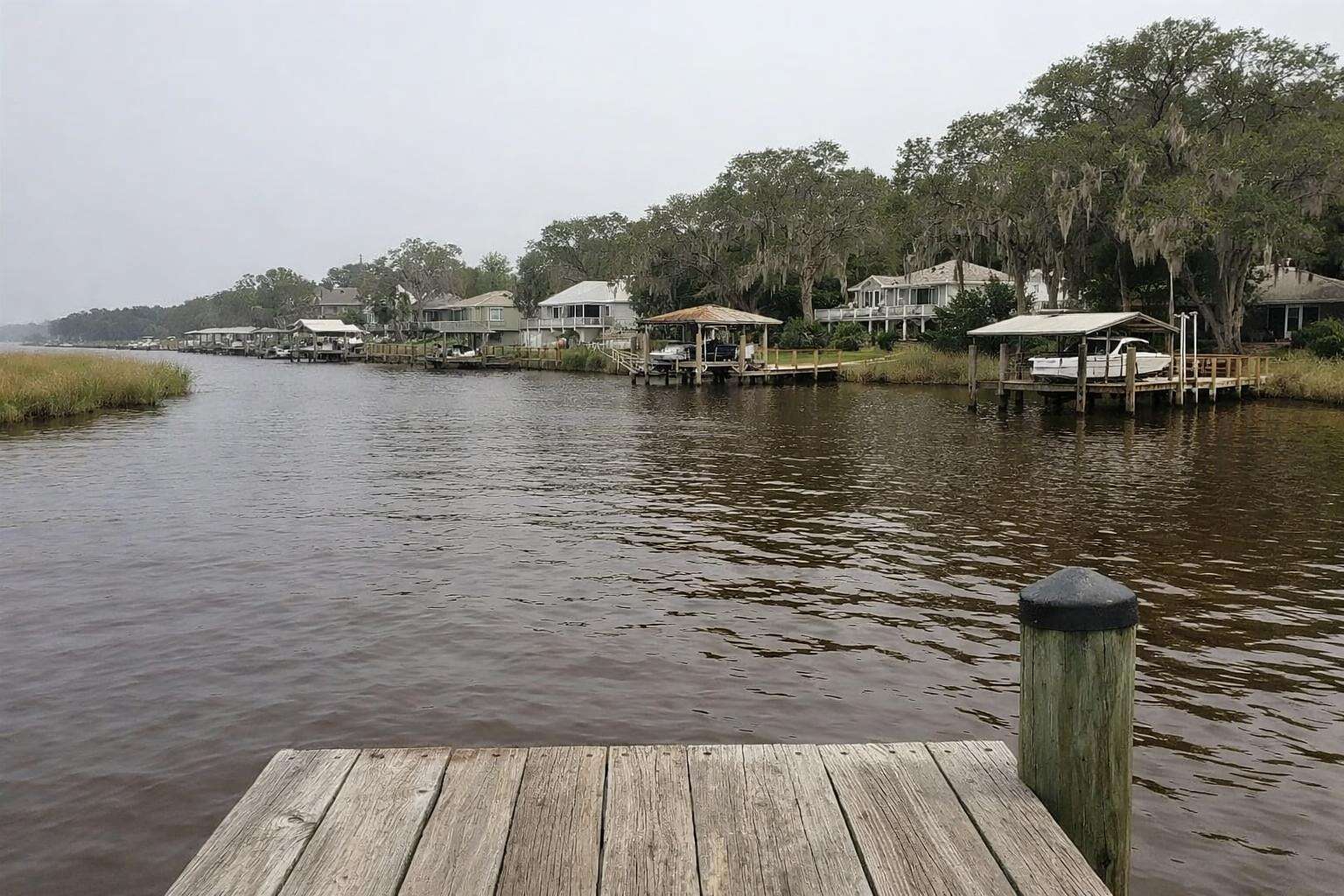 Houses with docks along a wide tidal creek