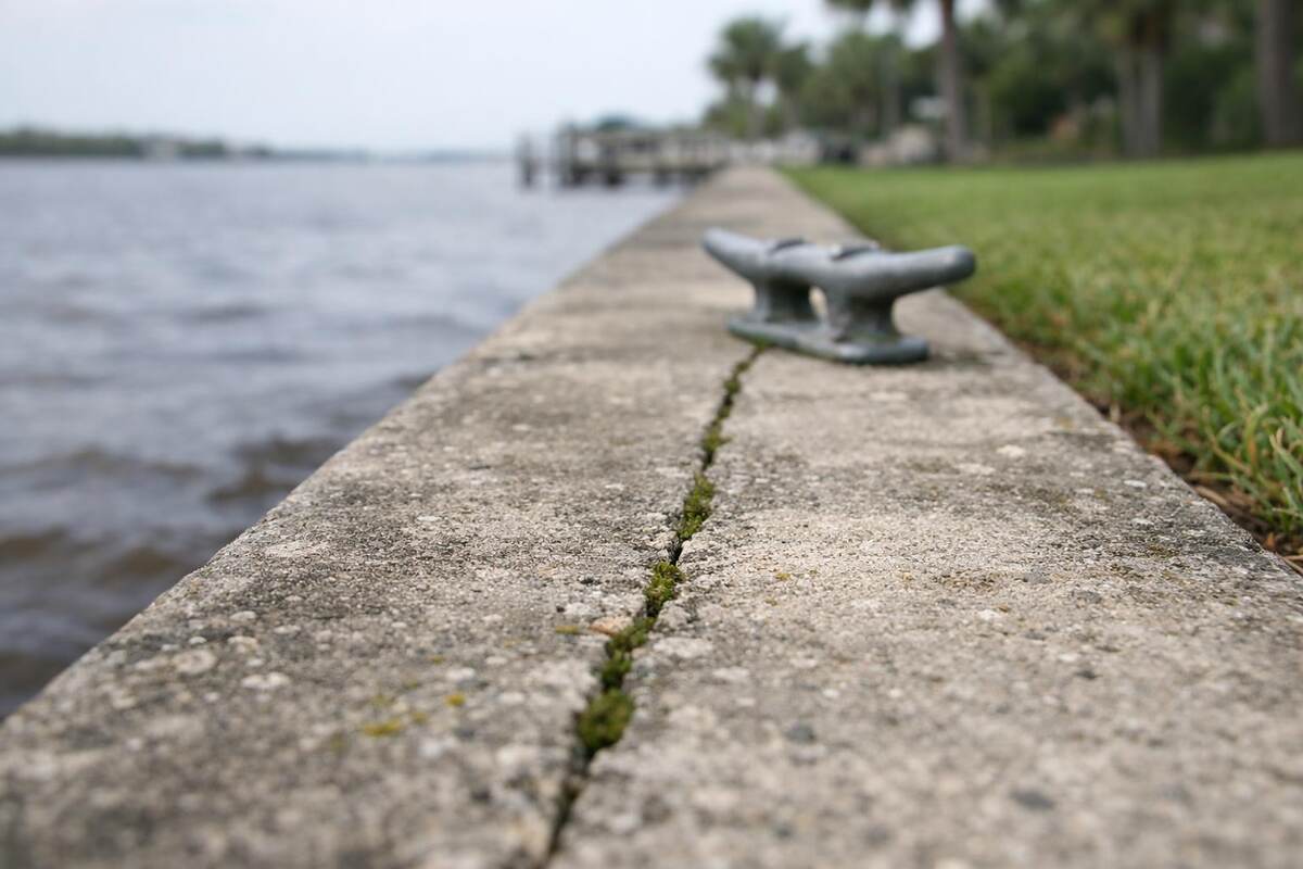 The cap of a concrete seawall at the edge of a river