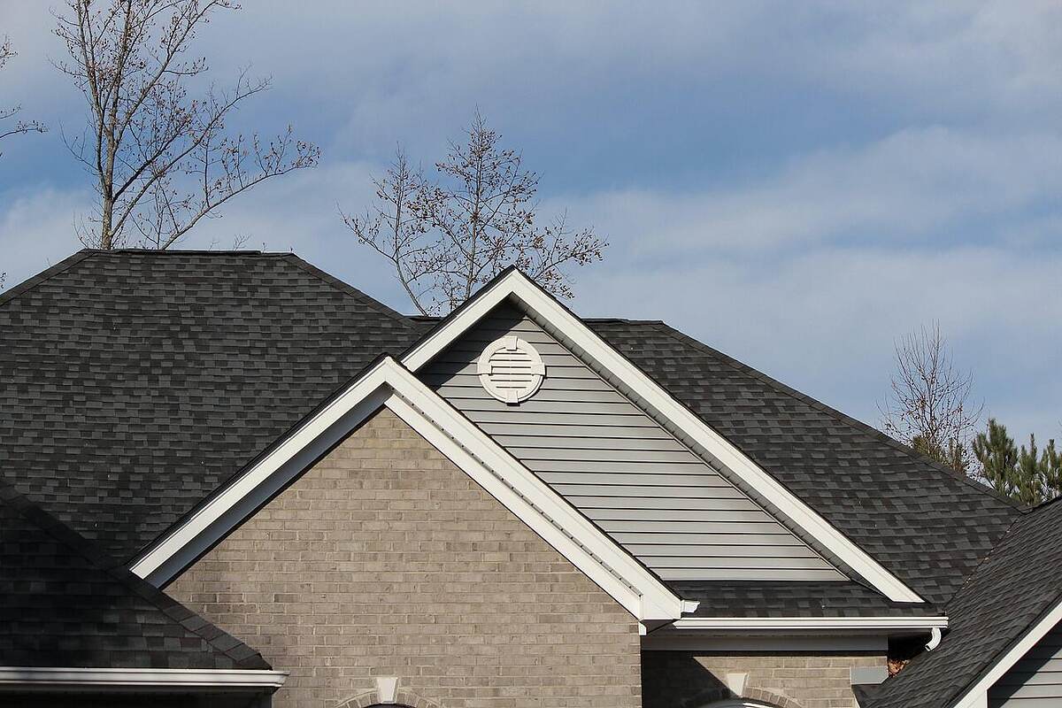 The shingle roofline and soffit of a two-story suburban house
