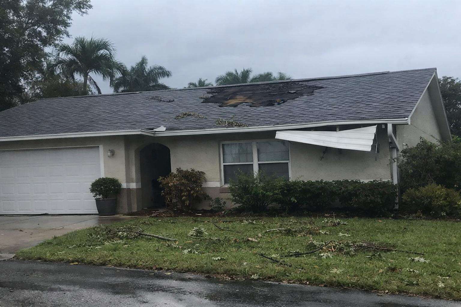 A shingle roof with sections torn away by a storm